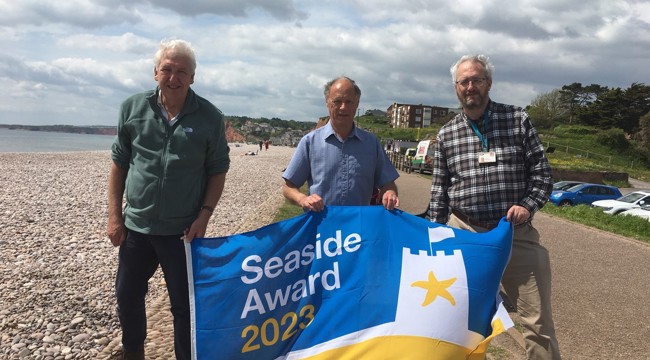 Council members and staff hold Seaside Award Flag in Budleigh 