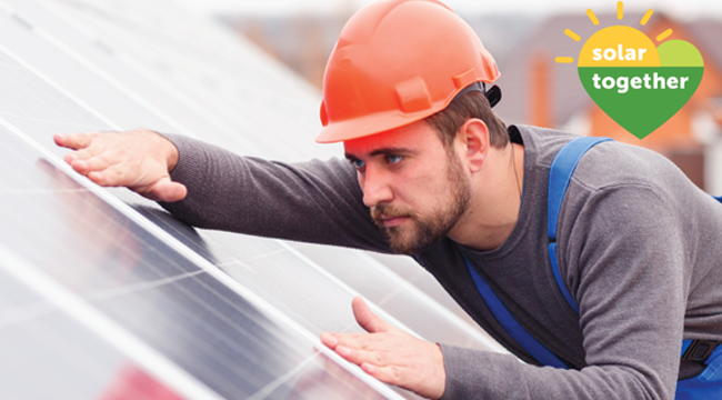 Worker fitting solar panels on a roof
