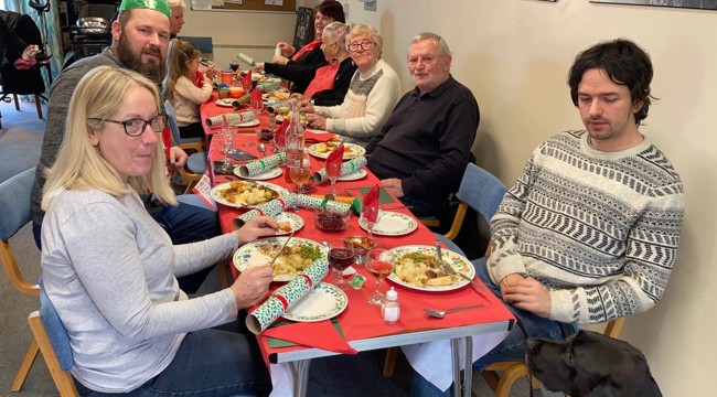 Warm hub users sit around a table for Christmas dinner