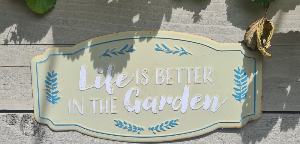 A small plaque saying life is better in the garden