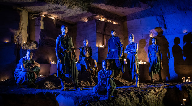 7 people stood in a cave in blue lighting