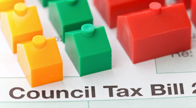 Photo of Council Tax bill with yellow, green, and red monopoly houses on top