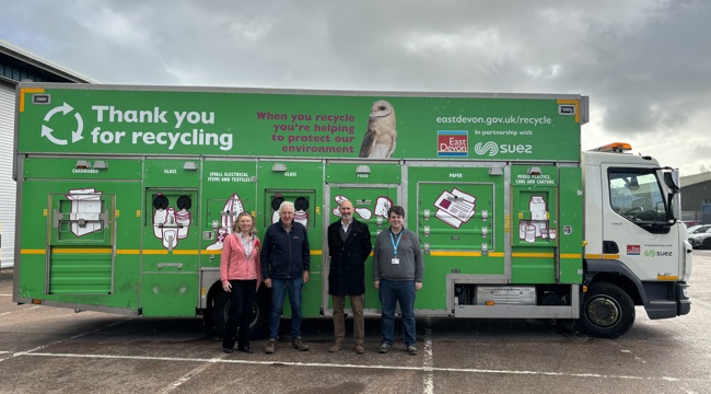 Group photo in front of a green East Devon District Council recycling truck. From left to right - Councillor Paul Fernley, Councillor Geoff Jung, Nick Tandy (Principal Commercial Manager for SUEZ), Councillor Todd Olive