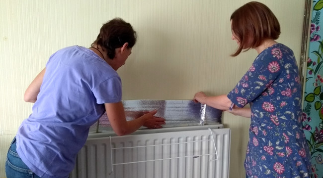 Photo of reflective radiator panels being installed. Credit: ECOE