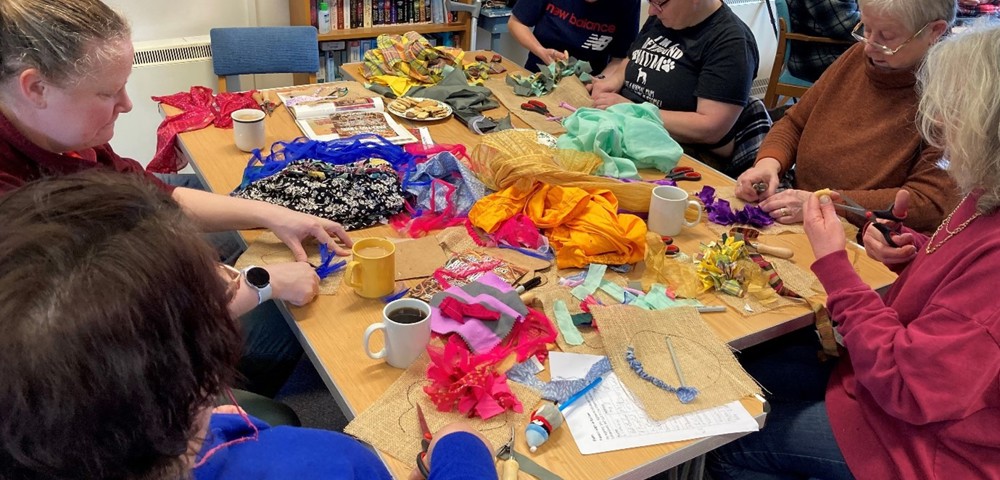A group of people creating crafts in a community hub