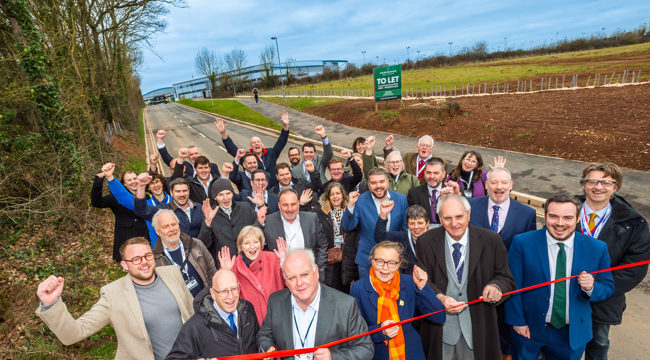 EDDC Leader Cllr Paul Arnott cuts a ribbon to open Long Lane, together with representatives from Devon County Council, the South West Local Enterprise Partnership, East Devon District Council, Simon Jupp MP, Exeter College, Exeter Airport, contractors and local VIPs. Photo credit: GRW Photography