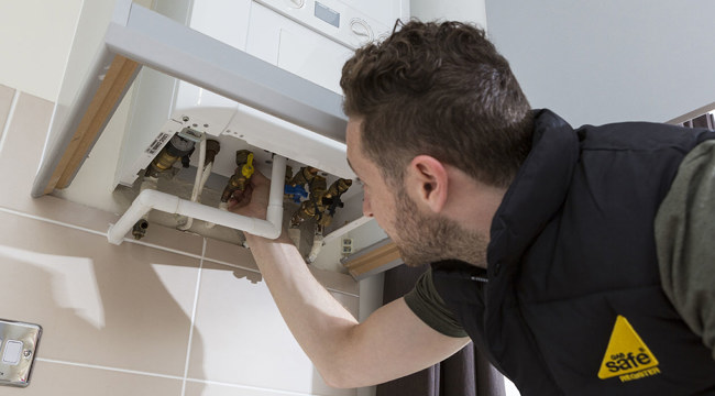 Photo of an engineer checking a boiler
