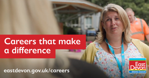 A woman wearing a lanyard talking to someone